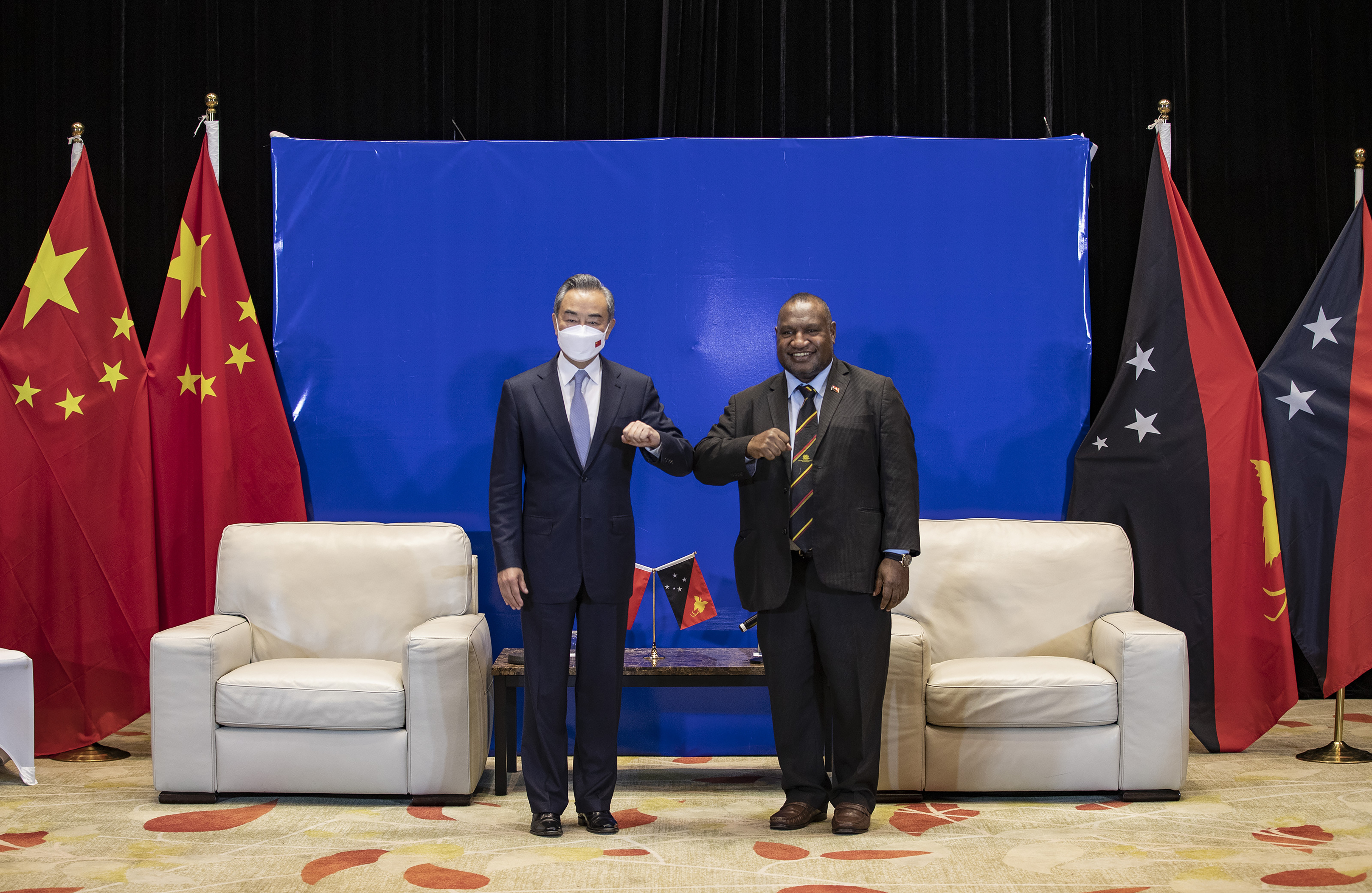 n this photo released by Xinhua News Agency, Papua New Guinea (PNG) Prime Minister James Marape at right bumps elbows with visiting Chinese Foreign Minister Wang Yi in Port Moresby, Papua New Guinea, Friday, June 3, 2022. The foreign ministers of Australia and China were both making their final stops Friday, June 3, 2022 on what has become an island-hopping diplomatic duel in the South Pacific. (Bai Xuefei/Xinhua via AP)