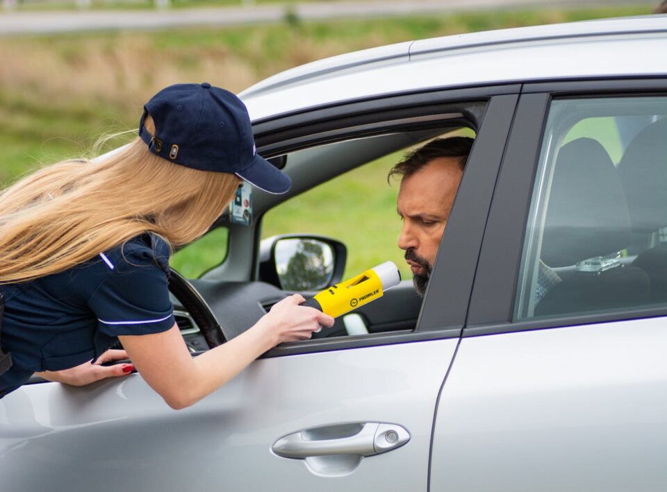 Photo by Łukasz Promiler: https://www.pexels.com/photo/police-officer-conducting-dui-check-on-driver-31154441/